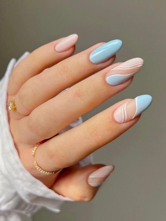 Lignes ondulées blanches sur ongles bleu clair