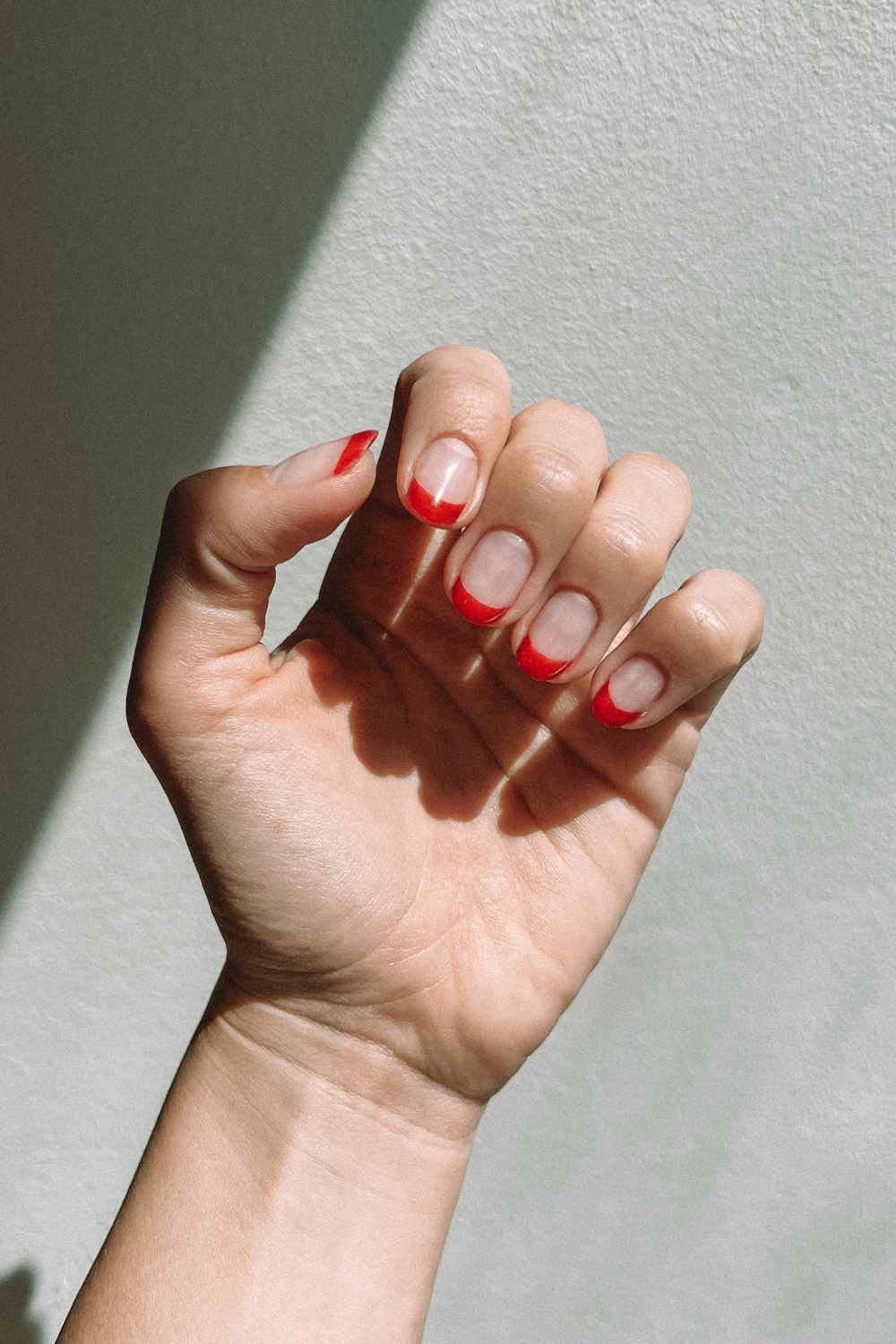 Ongles rouges à pointe française avec fond blanc