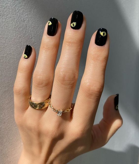 Vernis à ongles noir avec des yeux effrayants nail art sur ongles courts