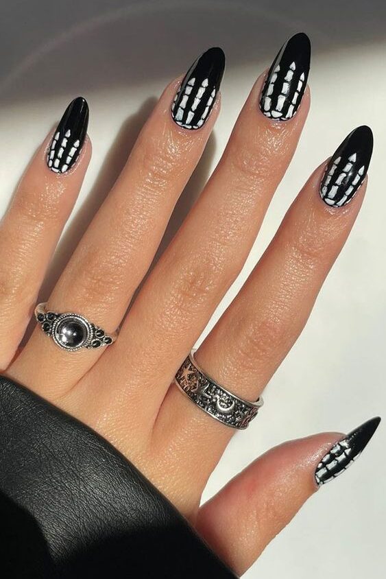 Vernis à ongles noir avec squelette nail arts sur ongles amandes moyennes