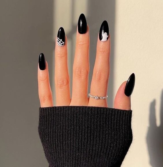 Vernis à ongles noir avec des ongles fantômes et toile d’araignée sur ongles en amande moyenne