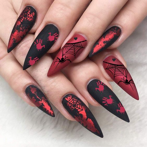 Vernis à ongles rouge noir et chrome avec des motifs d’ongles d’Halloween effrayants sur de longs ongles à talons aiguilles