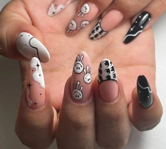 Nail art de visages souriants noirs et blancs sur de longs ongles en amande