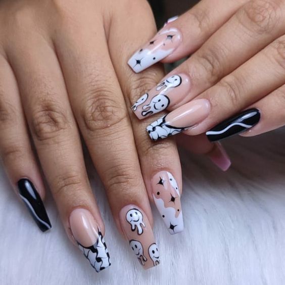 Nail art de visages souriants noirs et blancs sur de longs ongles en acrylique en forme de cercueil