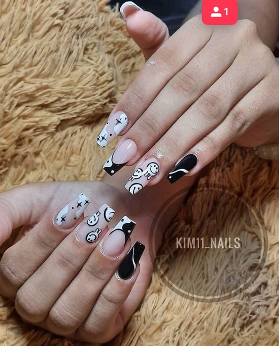 Nail art de visages souriants noirs et blancs sur de longs ongles carrés