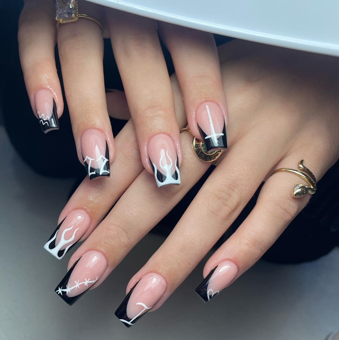 Pointes françaises noires avec flammes blanches et motifs d’ongles du signe du Verseau sur ongles carrés effilés moyens