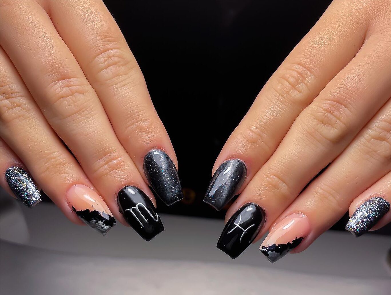 Vernis à ongles noir finition brillante avec des paillettes et des étoiles de signe Poissons sur de longs ongles de cercueil