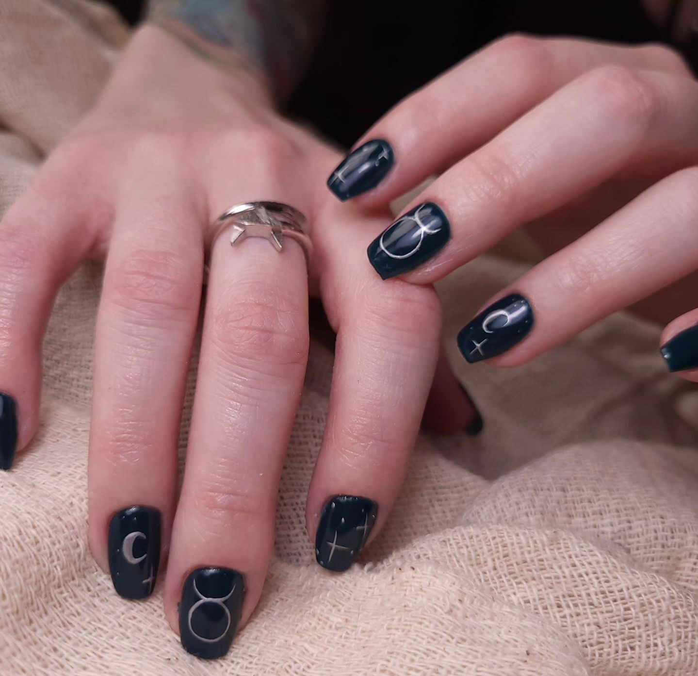 Vernis à ongles noir avec signe Taureau et éléments célestes nail arts sur ongles carrés effilés moyens