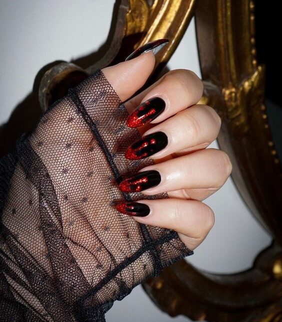 Vernis à ongles noir avec un design d’ongles rouge vif dégoulinant de sang sur de longs ongles ronds