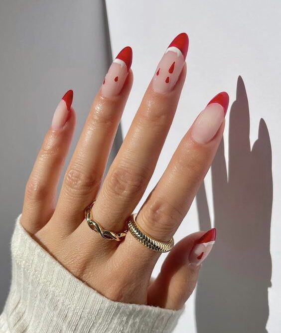 Pointes françaises rouge vif avec des dents de vampire nail art et du sang dégoulinant sur de longs ongles en amande