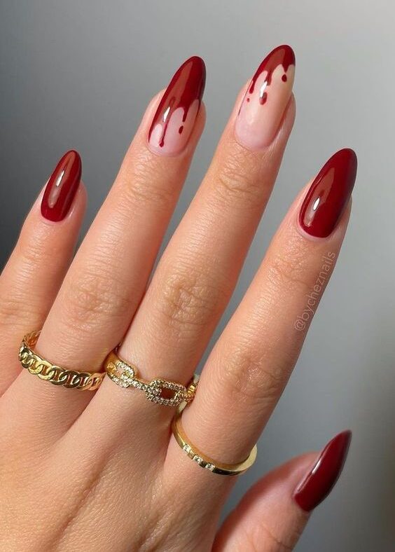 Vernis à ongles rouge foncé au fini brillant avec nail art sang dégoulinant sur les ongles longs en amande