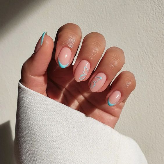 Pointe fine française bleu clair et nail art papillon sur ongles courts en amande