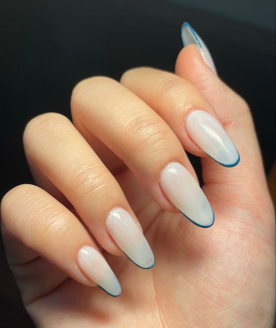 Ongles en acrylique blancs longs et ronds avec des pointes françaises fines bleues