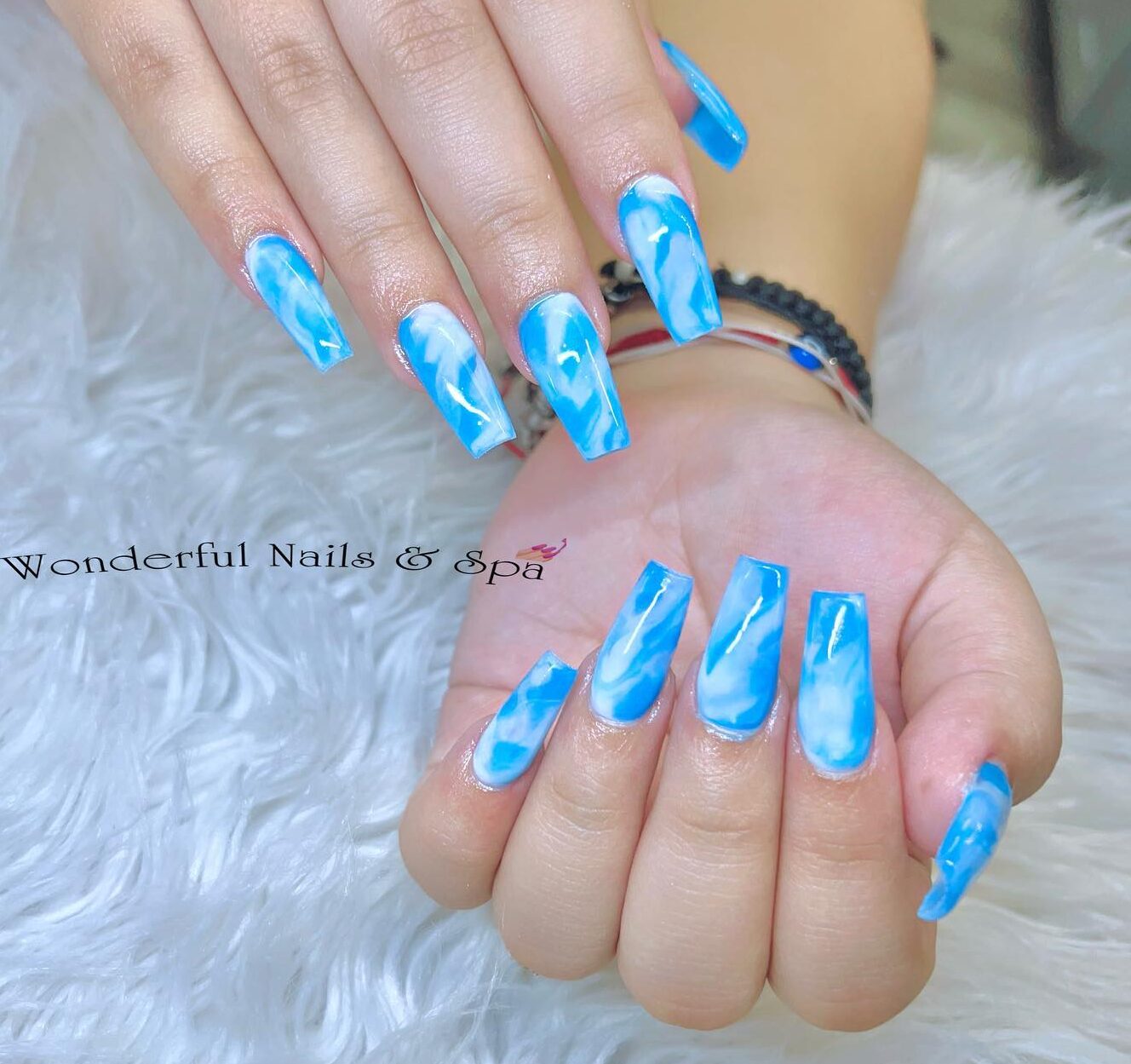 Nail art en marbre bleu clair sur de longs ongles en acrylique effilés de forme carrée