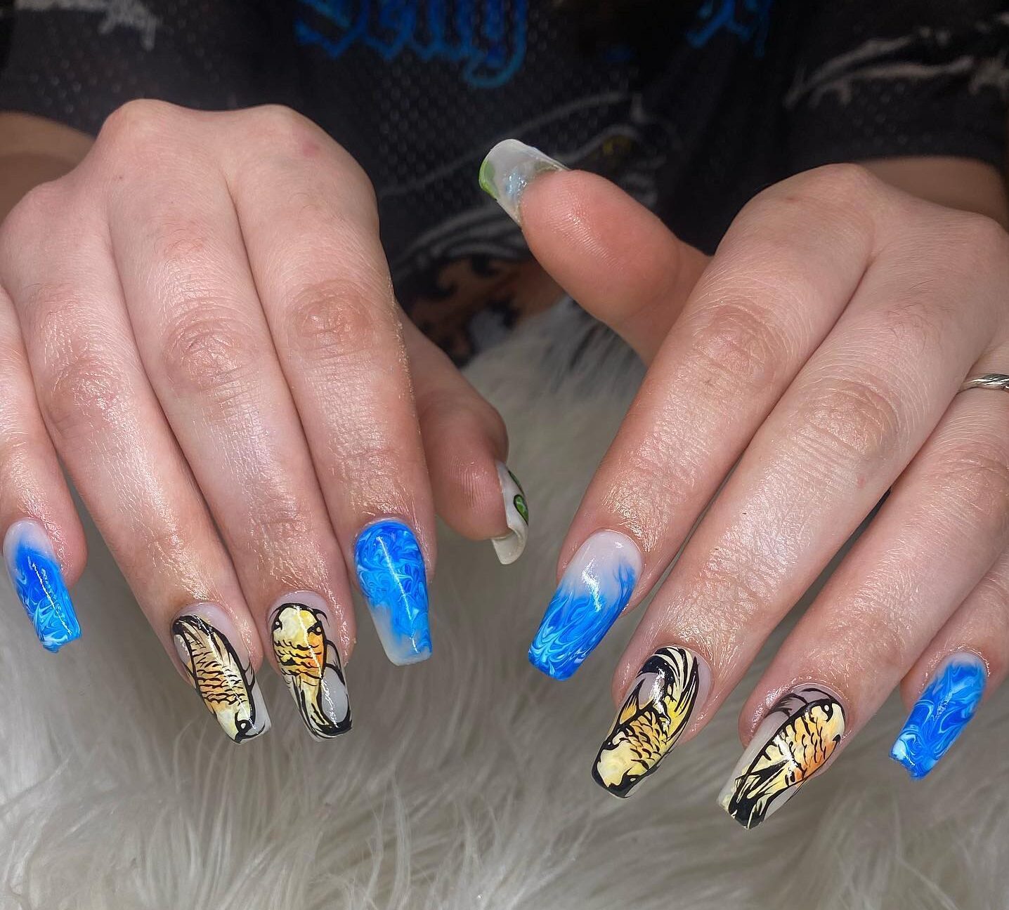 Motifs d’ongles de marbre bleu et de poisson koi sur de longs ongles en acrylique en forme de cercueil