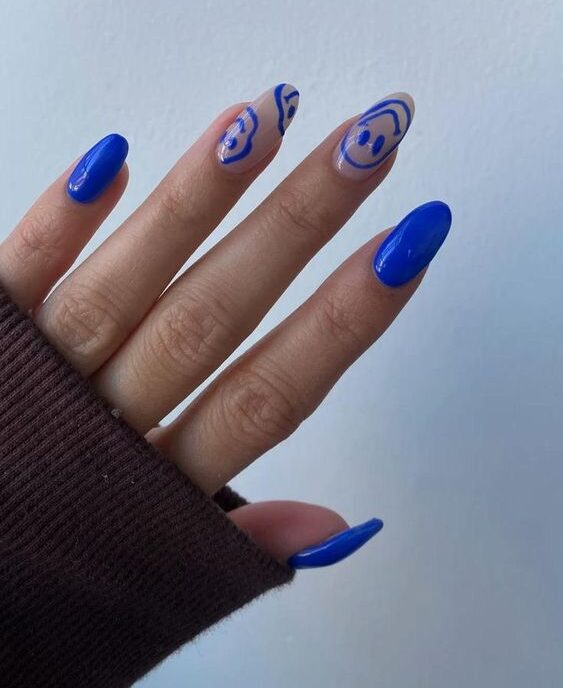 Vernis à ongles bleu royal et smiley visages bleu roi nail art sur ongles longs ronds