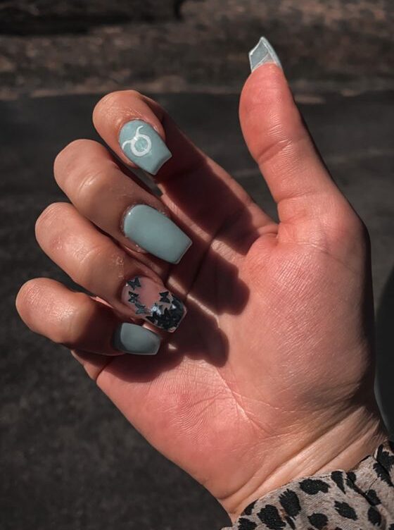 Couleur d’ongle bleu clair avec signe Taureau nail art sur ongles carrés longs et effilés