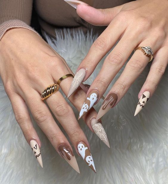 Nuances de vernis à ongles brun en finition mate avec des nail arts d’Halloween sur de longs ongles aiguilles