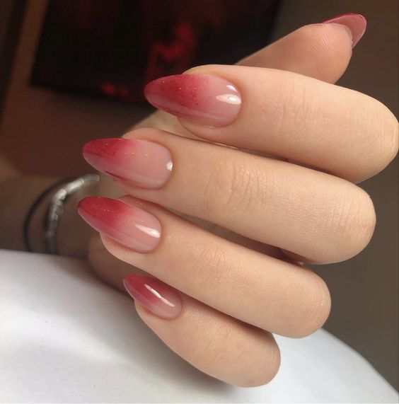 Conception d’ongles à effet ombré rouge bordeaux pâle sur les ongles en amande moyenne