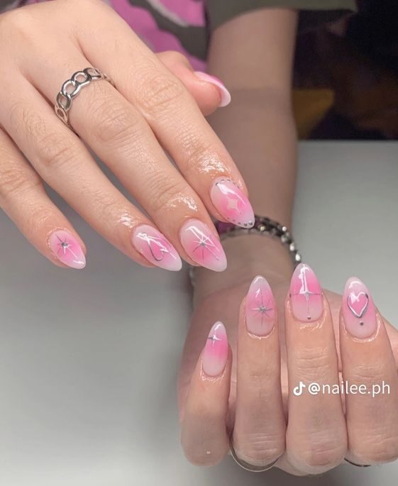 Effet dégradé d’aura rose clair avec des éléments célestes nail arts sur ongles acryliques moyens en forme d’amande