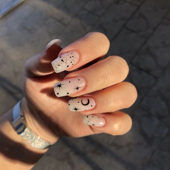 Ongles en acrylique de forme carrée longue et blanche pâle avec des éléments célestes