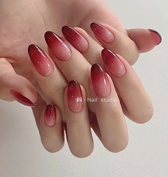 Nail art ombré rouge vin et rose en finition brillante sur ongles ronds moyens