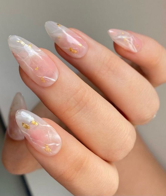 Ongles en amande clairs avec flocons d’or