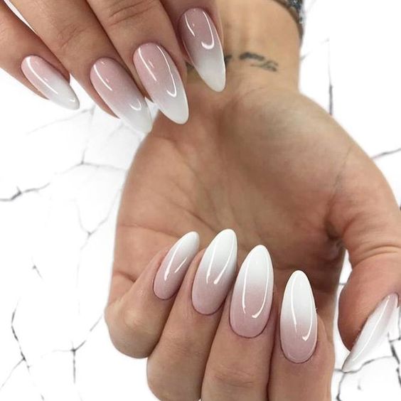 Conception d’ongles ombrés blancs et nude sur de longs ongles en amande