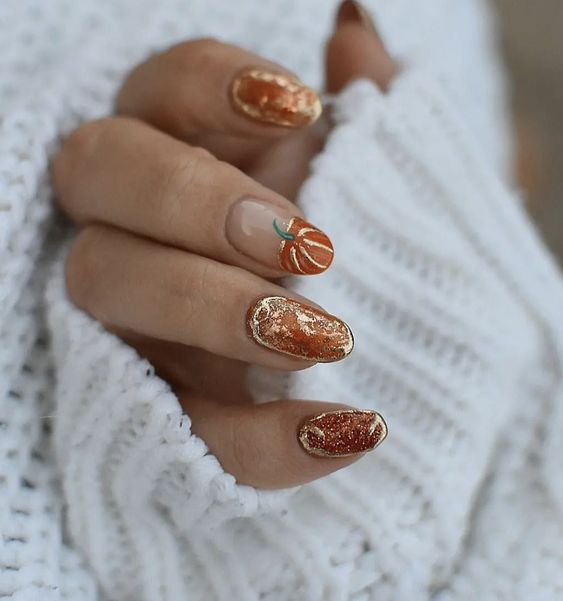 Couleur d’ongles orange brûlé avec paillettes et art d’ongle citrouille sur ongles ronds moyens