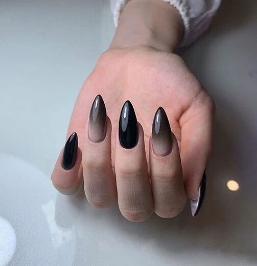 Conception d’ongles à effet ombré noir de jais au fini brillant sur les ongles longs à talons aiguilles