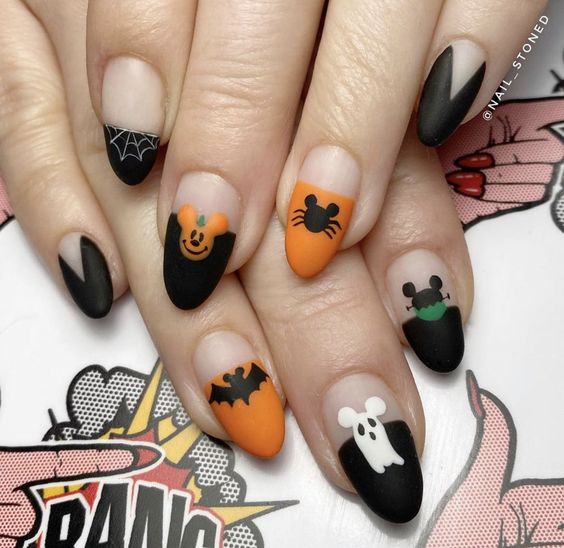 Vernis à ongles noir et orange au fini mat avec des nail arts d’Halloween inspirés de Disney sur des ongles ronds moyens