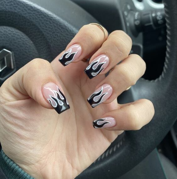 Nail art flammes noires avec des contours argentés sur des ongles carrés moyens