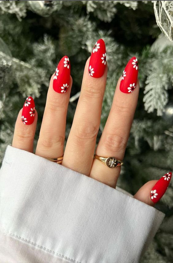 Vernis à ongles rouge et fleurs blanches sur ongles en amande