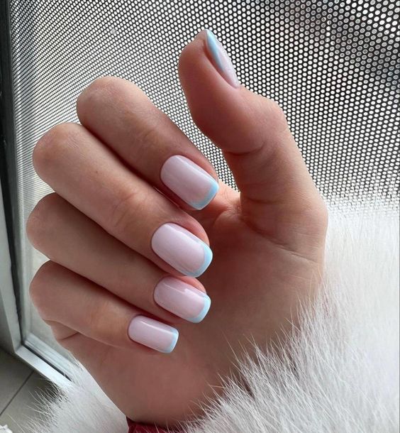 Vernis à ongles blanc pâle avec pointes françaises bleu clair nail art sur ongles carrés courts et effilés