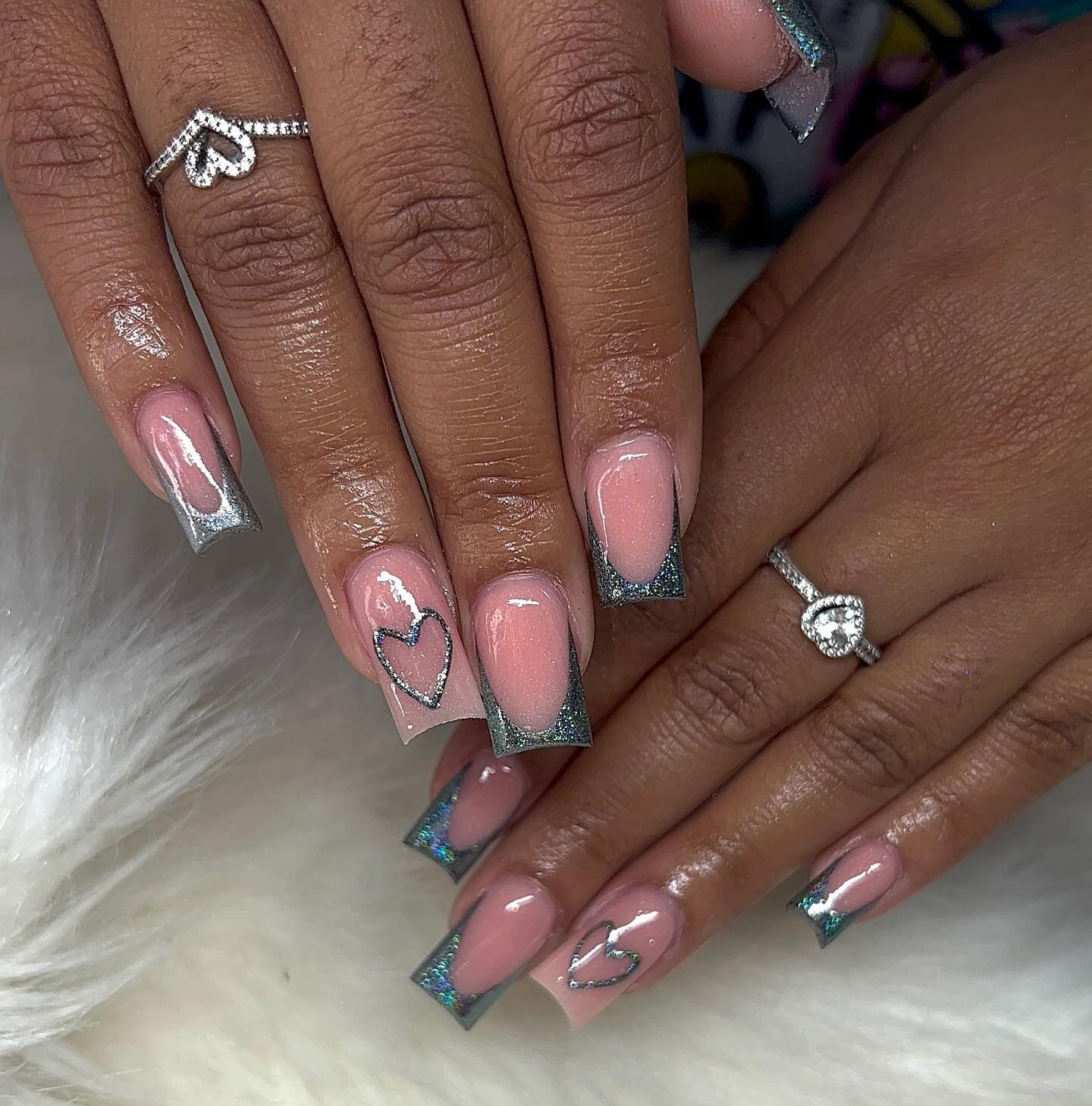 Ongles en acrylique de forme carrée moyenne avec des pointes françaises en argent métallique et des cœurs en argent nail art