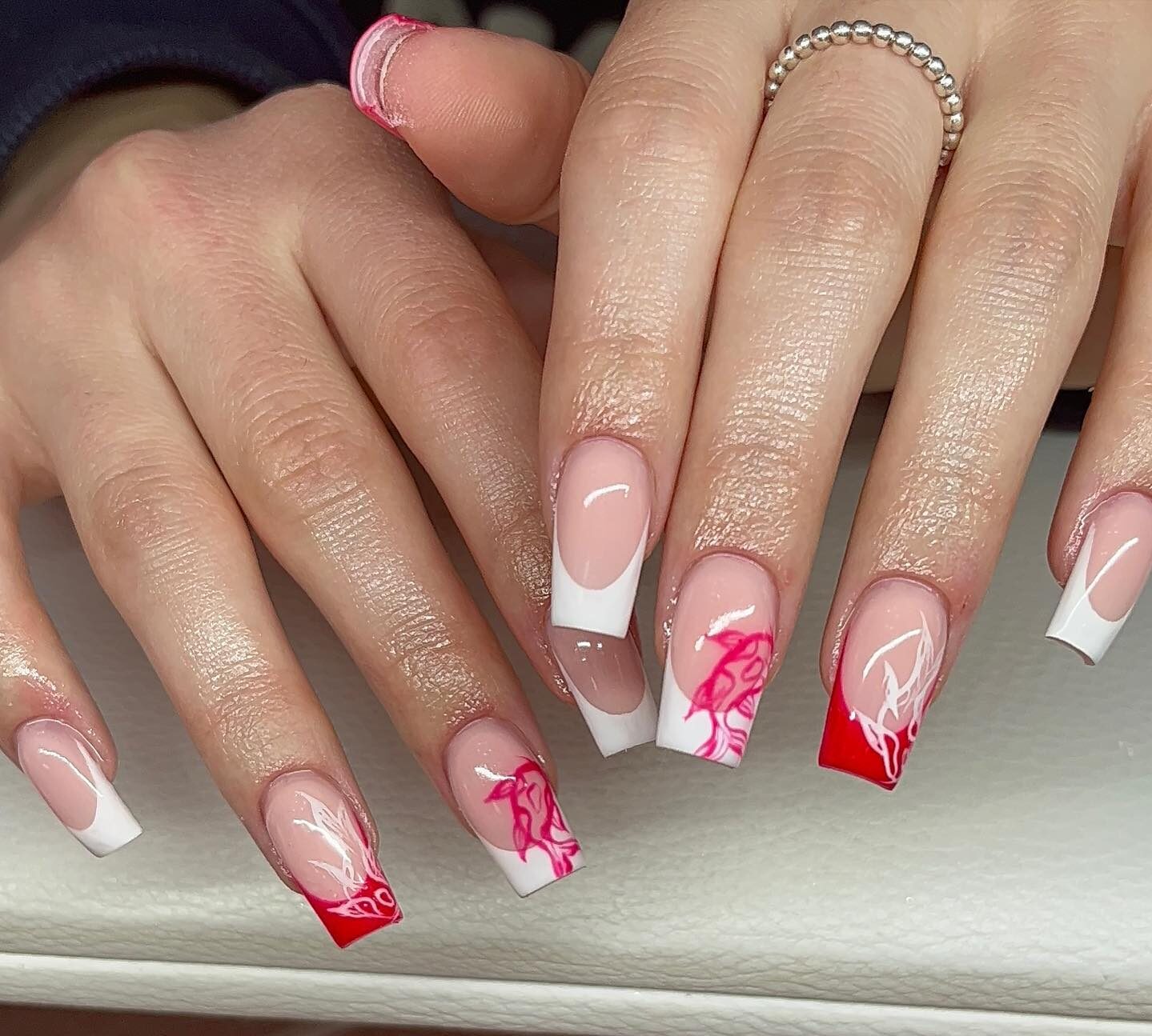 Pointes françaises rouges et blanches avec des motifs d’ongles de carpe koï sur de longs ongles carrés