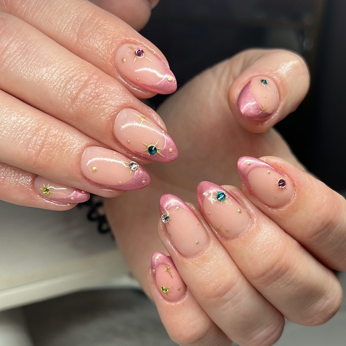 Chrome rose pastel pointes françaises avec éléments célestes nail arts sur ongles ronds moyens