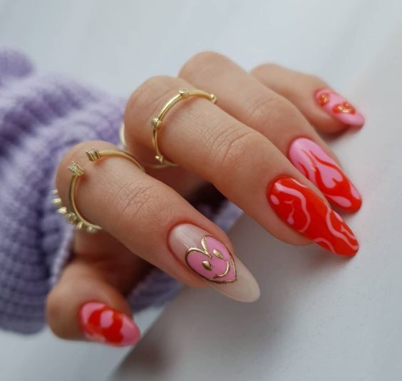 Couleur d’ongles rose et rouge avec nail art flamme, cœurs et smileys sur de longs ongles ronds