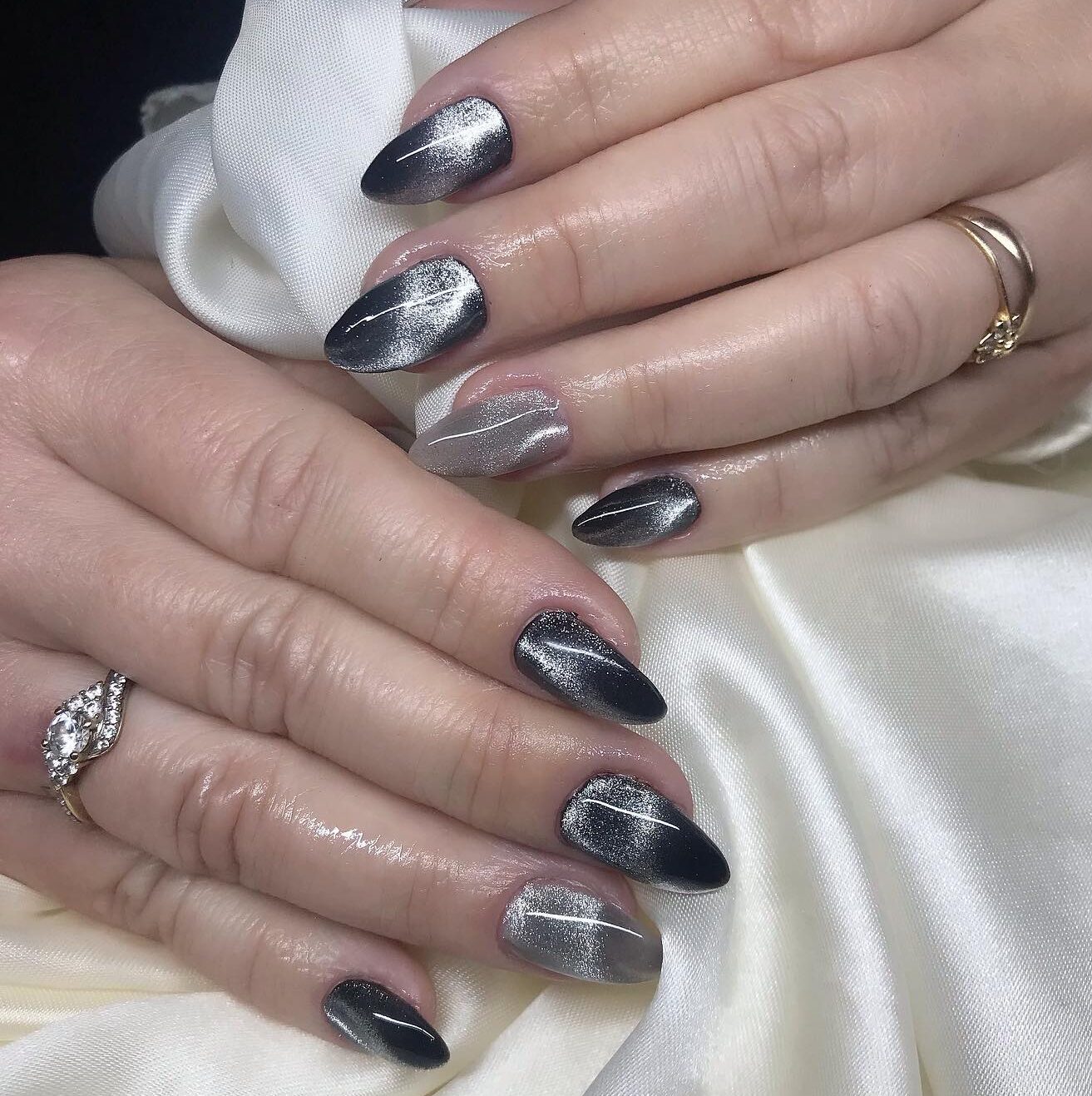 Nail art noir et argenté scintillant comme une galaxie sur les ongles en amande moyenne