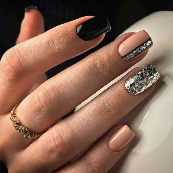 Vernis à ongles nude et noir avec des paillettes argentées sur des ongles carrés courts et effilés