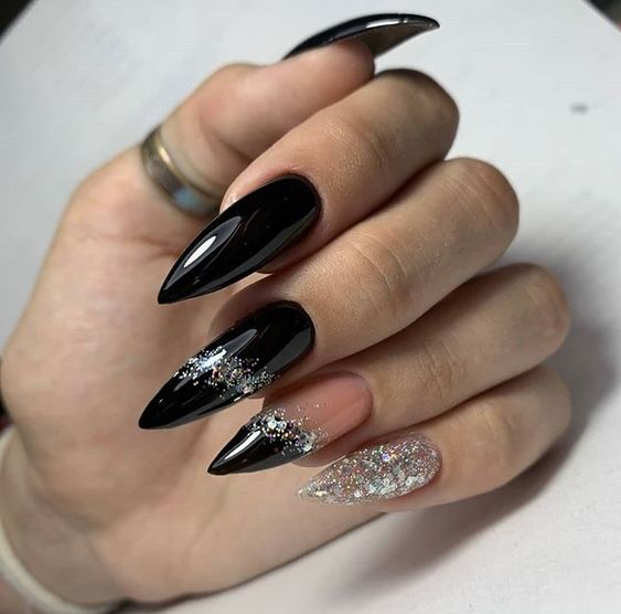 Vernis à ongles noir finition brillante avec des paillettes argentées nail art sur les ongles longs stiletto