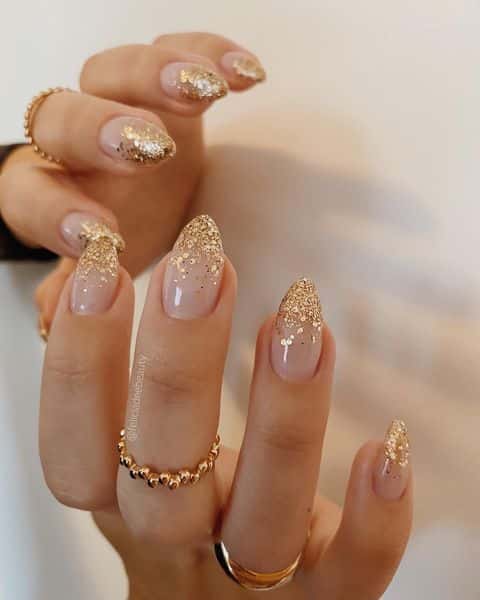 Paillettes dorées pointes françaises sur ongles ronds moyens clairs