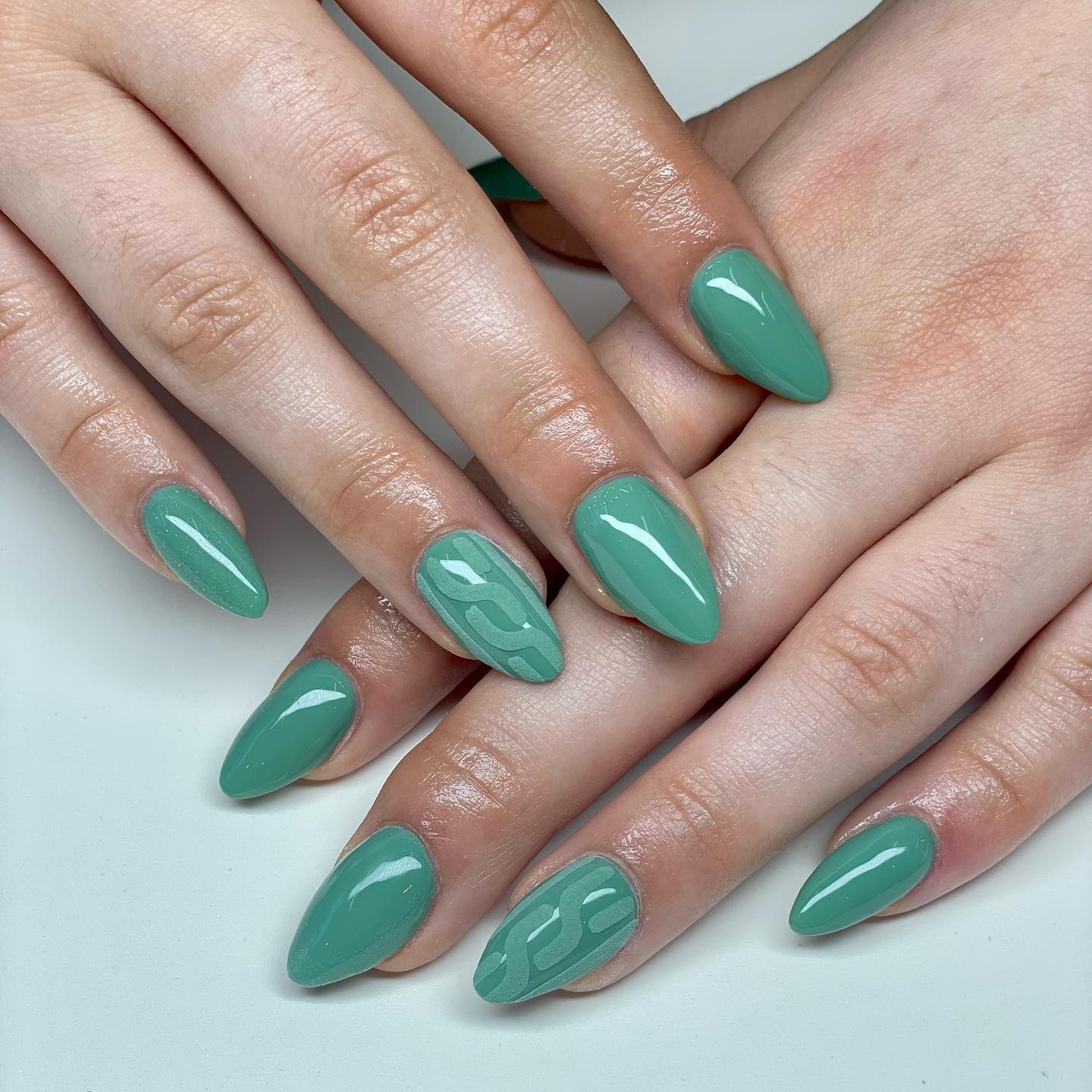 Vernis à ongles vert tendre avec motif géométrique nail art sur ongles amandes moyennes