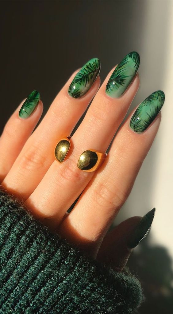 Ongles verts avec des plantes sur des ongles en amande