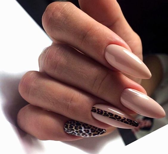 Couleur d’ongles nude avec nail art imprimé léopard sur des ongles en amande super longs