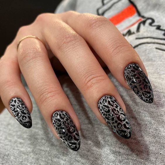 Nail art imprimé léopard noir et argent sur ongles longs en amande