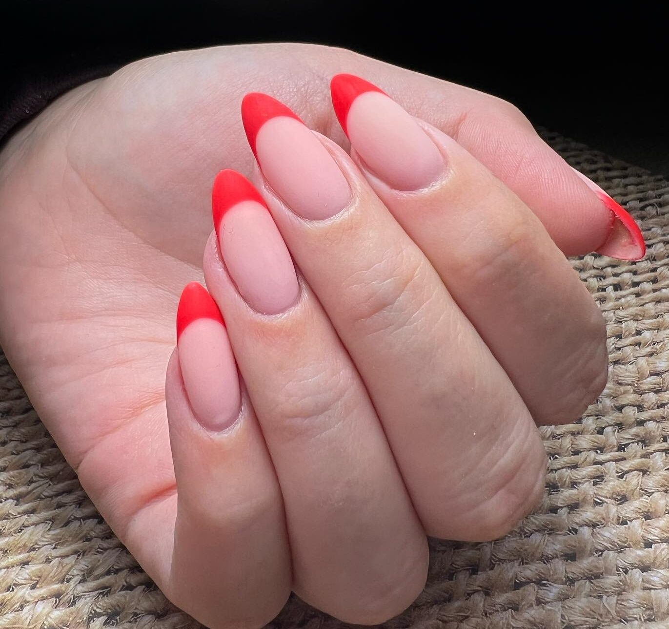 Finition mate : pointes françaises rouges sur ongles en amande moyenne