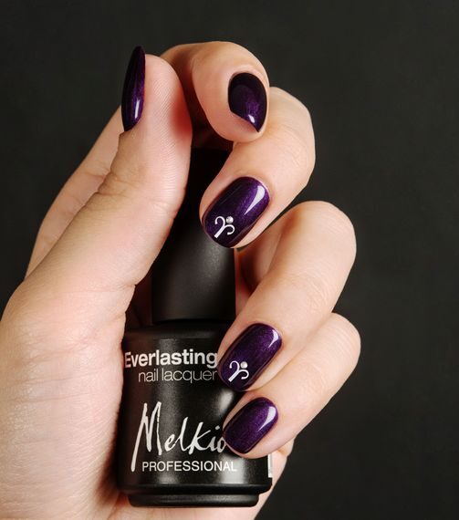 Couleur d’ongle violette finition brillante avec nail art minimaliste du signe Bélier sur les ongles courts