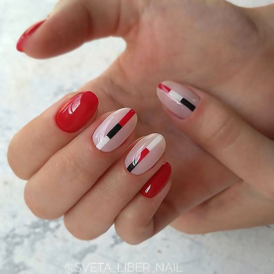 Motifs d’ongles minimalistes et vibrants rouges, blancs et noirs en finition brillante sur des ongles ronds courts