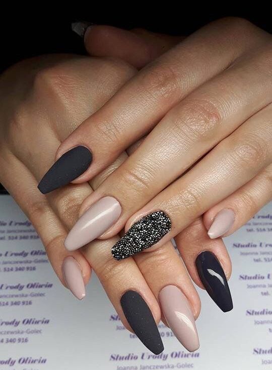 Finition mate et brillante, couleurs d’ongles noires et nude sur les ongles longs en amande